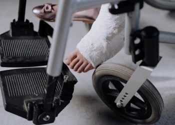 Foot in cast resting on a wheelchair footrest after toe fracture treatment