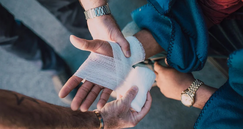 Medical professional wrapping a bandage around a patient's broken wrist