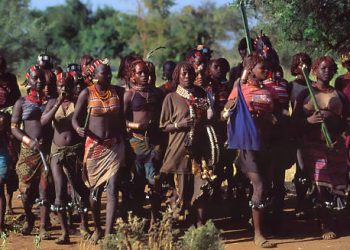 Group of traditionally dressed women in a rural setting, representing cultural practices