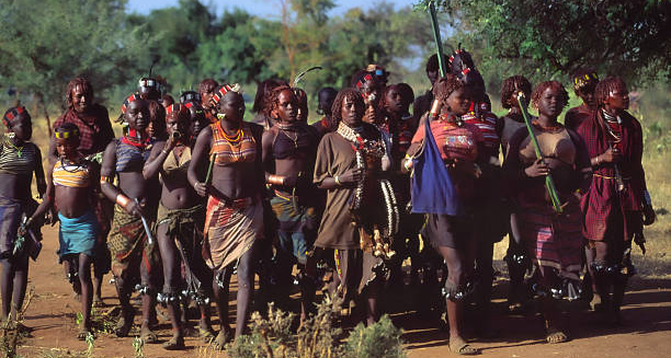 Group of traditionally dressed women in a rural setting, representing cultural practices