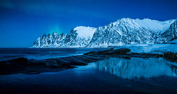 Snow-covered mountains and icy landscape under cold blue twilight