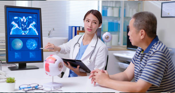 Eye specialist explaining digital retinal scans to an older male patient