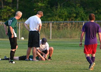 Football player receiving medical attention after head injury, a common cause of concussion