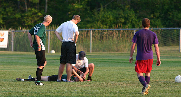 Football player receiving medical attention after head injury, a common cause of concussion