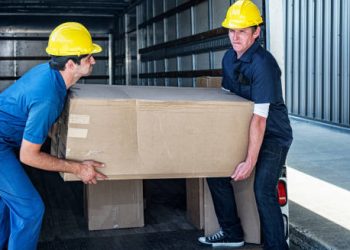 Two workers lifting a heavy box, potentially straining their chest muscles, which can lead to costochondritis.