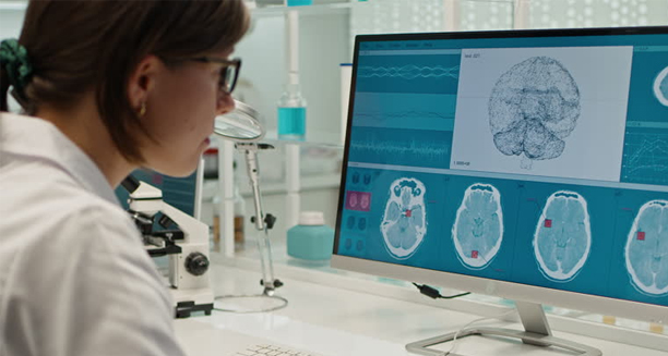 Researcher examining brain scans on a computer to study neurological causes of cyclothymia