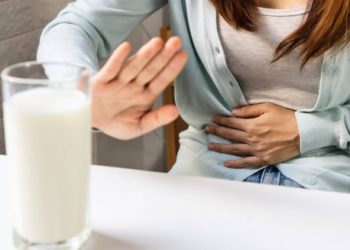 Woman with stomach pain refusing milk due to lactose intolerance