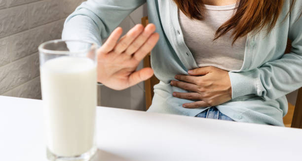 Woman with stomach pain refusing milk due to lactose intolerance
