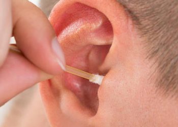 Person using a cotton swab to clean their ear canal