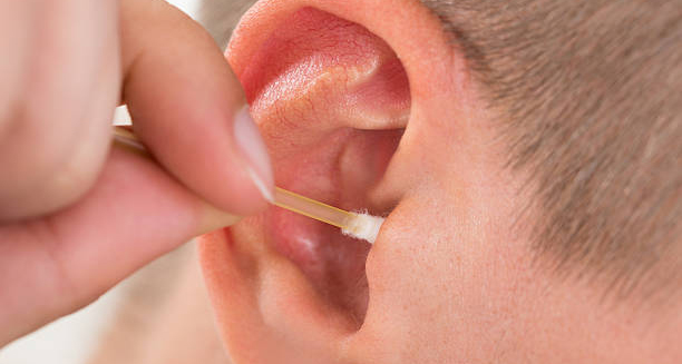 Person using a cotton swab to clean their ear canal
