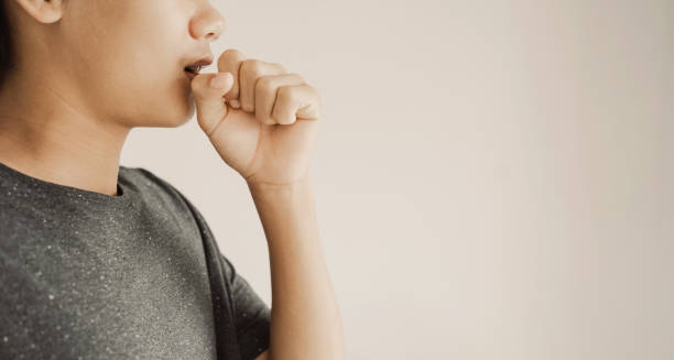 Woman coughing, possibly showing signs of infection linked to erythema nodosum