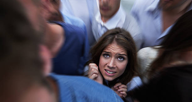Woman feeling trapped in a crowd, showing signs of claustrophobia