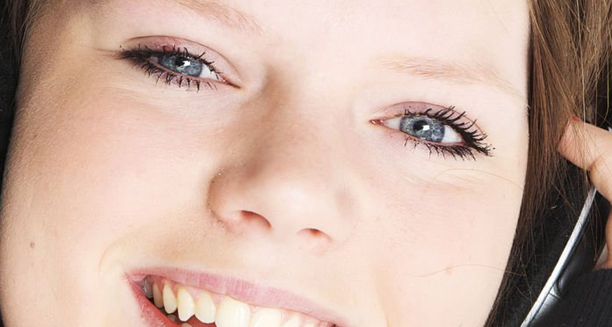 Close-up of a smiling child after cataract treatment with clear blue eyes