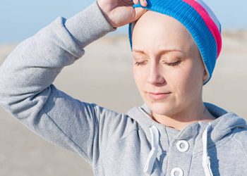Woman in recovery wearing a colourful beanie after treatment for chronic myeloid leukaemia