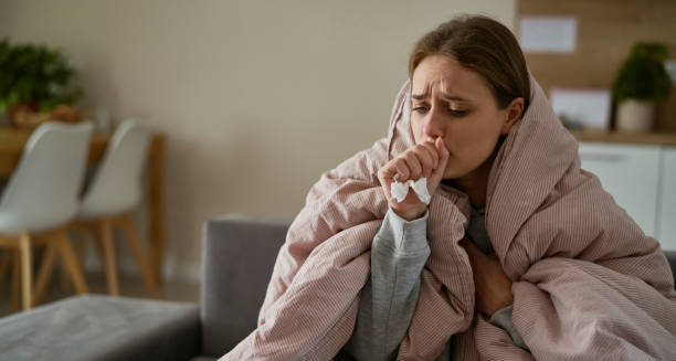 Woman coughing and wrapped in a blanket, showing complications of chronic obstructive pulmonary disease.