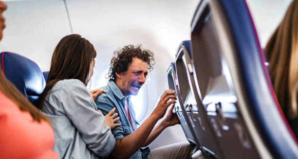 Man experiencing severe claustrophobia during a flight with supportive companion.