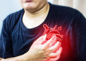 Man clutching chest with a digital heart illustration, representing complications from congenital heart disease
