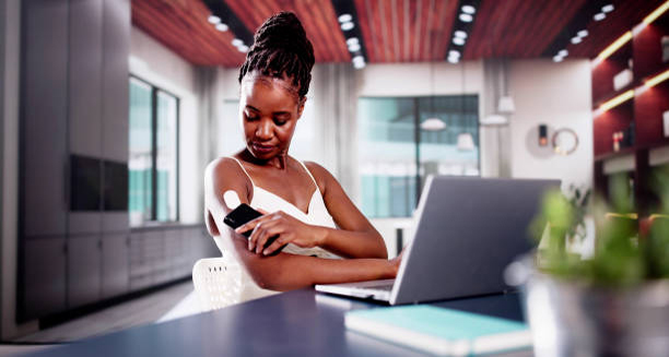 Woman using a continuous glucose monitor on her arm to manage diabetes complications and recovery