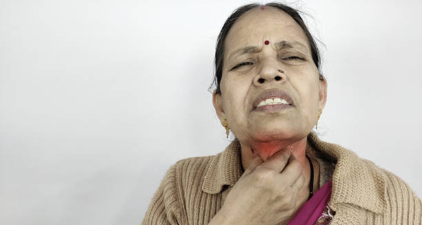 Elderly woman experiencing severe throat pain due to diphtheria