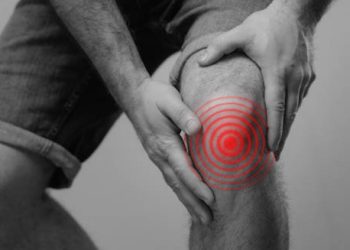 Man holding knee in pain with red target zone indicating dislocation complication