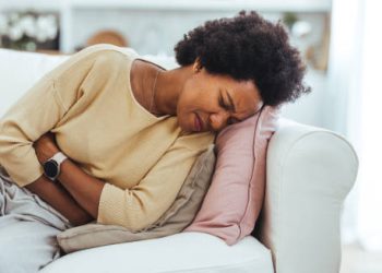 Woman in pain holding abdomen, showing complications of ectopic pregnancy.