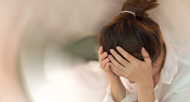 Woman holding head in distress due to encephalitis complications.