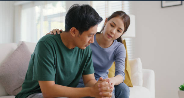 Man sitting in emotional distress with partner comforting him, representing complications of epididymitis