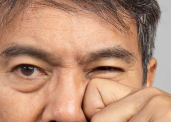 Man experiencing discomfort from eye cancer complications