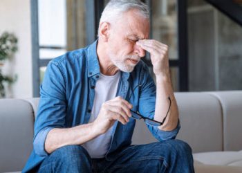 Elderly man experiencing eye discomfort from infection complications