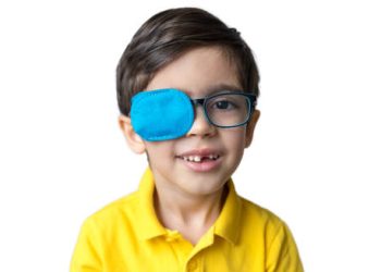 Young boy wearing glasses with an eye patch on one eye