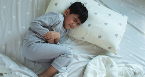 Young boy in pain holding his stomach during a febrile seizure episode