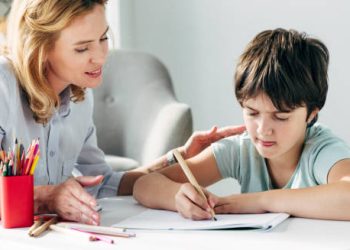 Teacher helping a young boy with learning difficulties