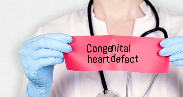 Doctor holding a red card labelled congenital heart defect