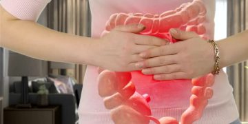 Illustration of a woman holding her abdomen highlighting an inflamed large intestine, representing constipation discomfort.