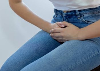 Woman clutching lower abdomen in discomfort due to bladder pain