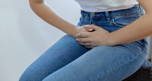 Woman clutching lower abdomen in discomfort due to bladder pain