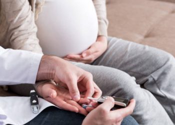 Doctor checking blood sugar of pregnant woman