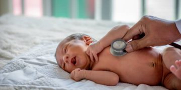 Doctor using a stethoscope to examine a newborn for congenital heart disease
