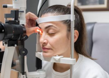 Woman undergoing eye examination for conjunctivitis diagnosis