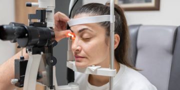 Woman undergoing eye examination for conjunctivitis diagnosis