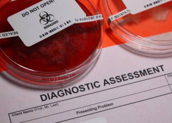 Laboratory diagnostic assessment form alongside sealed biohazard petri dishes, indicating medical testing in progress.