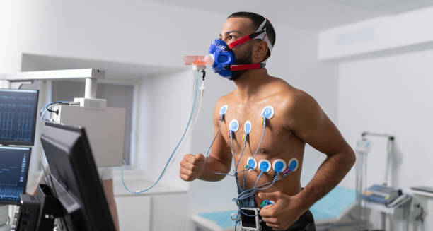 Man undergoing cardiopulmonary exercise testing with sensors and a breathing mask, part of diagnostic evaluation for cystic fibrosis.