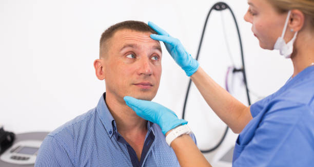 Healthcare professional examining a man's forehead and eyes for dehydration signs