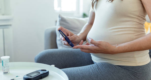 Pregnant woman checking blood sugar with a glucose meter, representing the diagnosis of diabetes in pregnancy