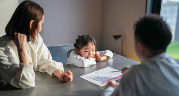 Child with short stature sitting at a table with parents and a doctor