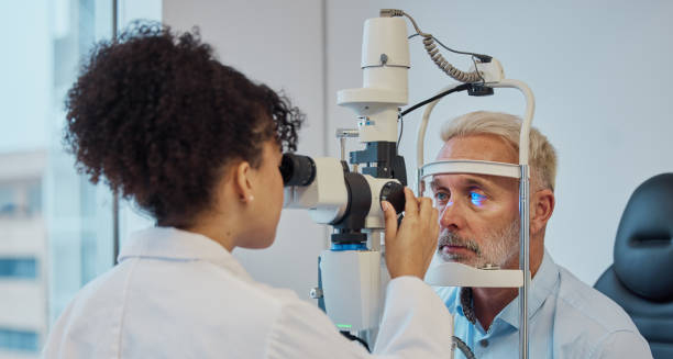 Ophthalmologist examining an older man's eye for signs of ectropion using a slit lamp.