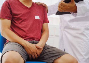 Doctor consulting a man with pelvic discomfort during diagnosis of enlarged prostate