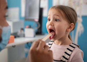 Paediatrician examining young girl for febrile seizure diagnosis