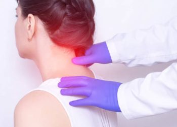 Doctor examining woman's neck for fibromyalgia diagnosis