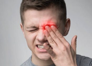 Man holding eye in pain with red inflammation indicating an eye injury